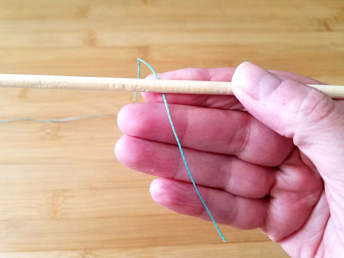 To begin the Figure 8 wire weave, place the weaving wire behind the first core wire with the starting tail of the weaving wire pointing down, as shown.