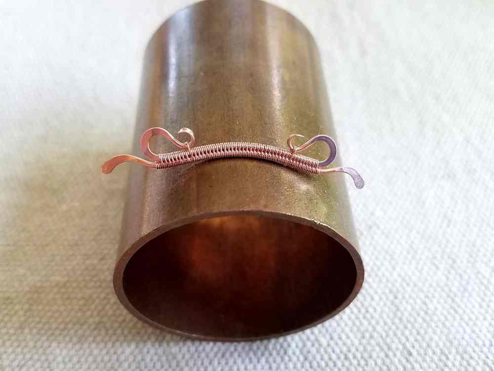 Delicate Bar Pendant, Step 13: Give the bar a very slight curve by forming it on a large mandrel. The mandrel shown is a short section of 1-1/2-inch copper pipe