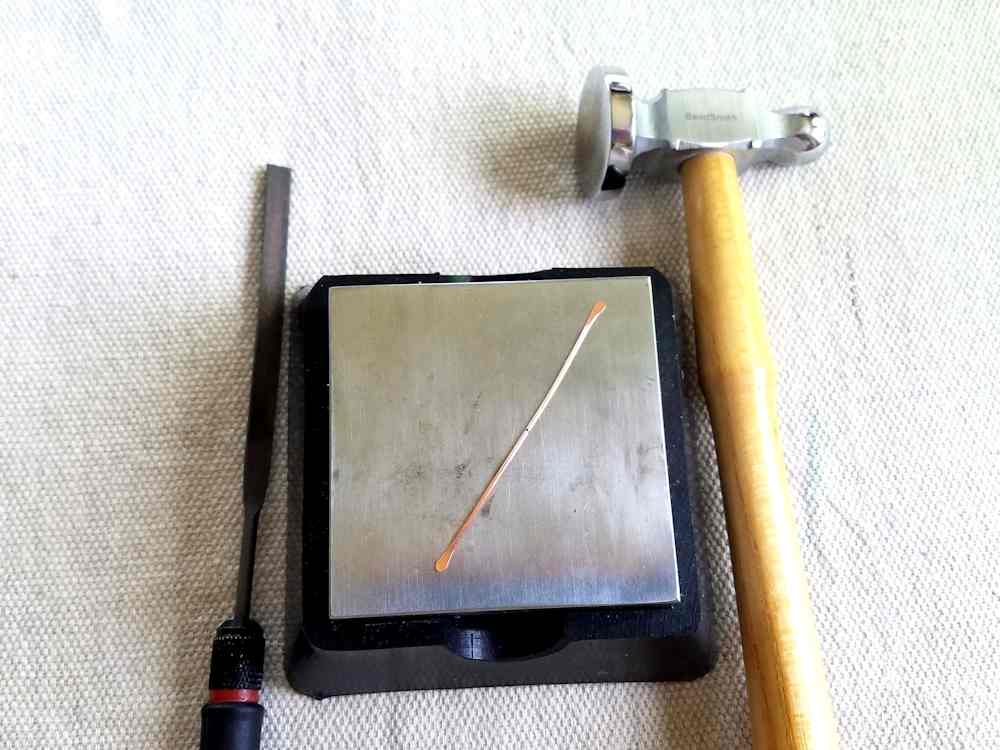Delicate Bar Pendant, Step 2: Paddle the ends of the longer of the two core wires using a bench block and chasing hammer. Refine the shape of the paddles with a needle file.