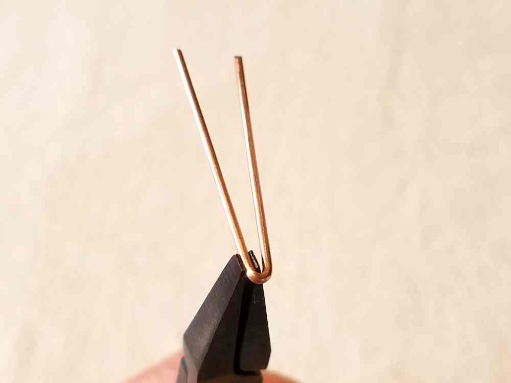 Begin forming the hook into a sharp V shape.