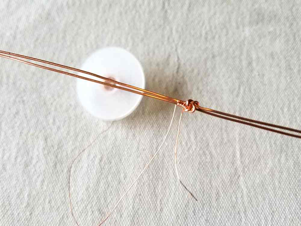 Secure weaving wire near the knot and weave the two core wires together using the Modified Soumak weave from the knot to the marks made at 3/8 inch from the end of the core wires.