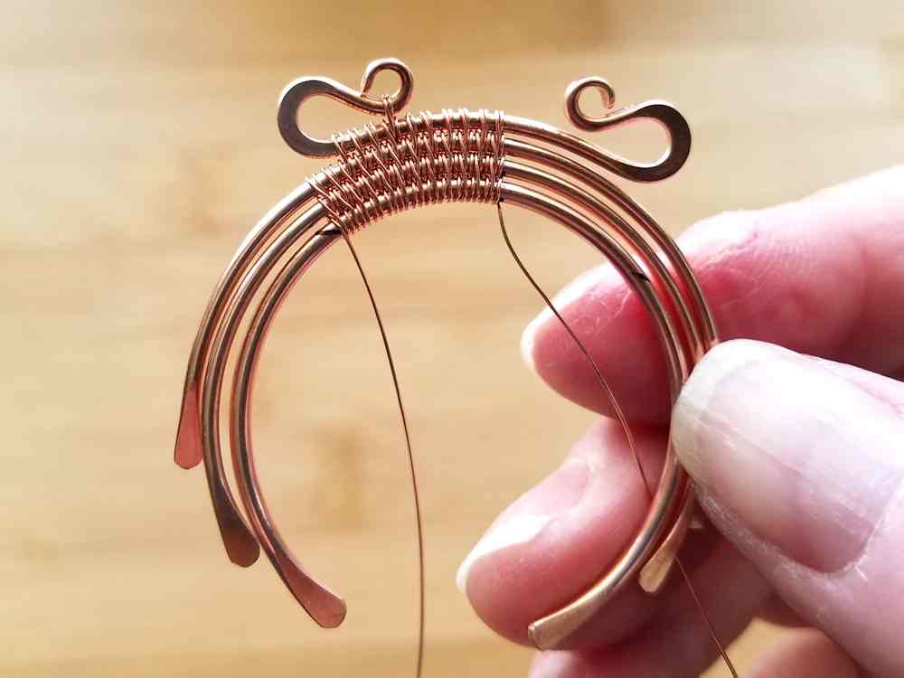 Step 14 - Begin weaving your core wires together, starting from the center marks you made before forming the core wires. Weave to the first mark you made for the bead's hole position in the previous step. 