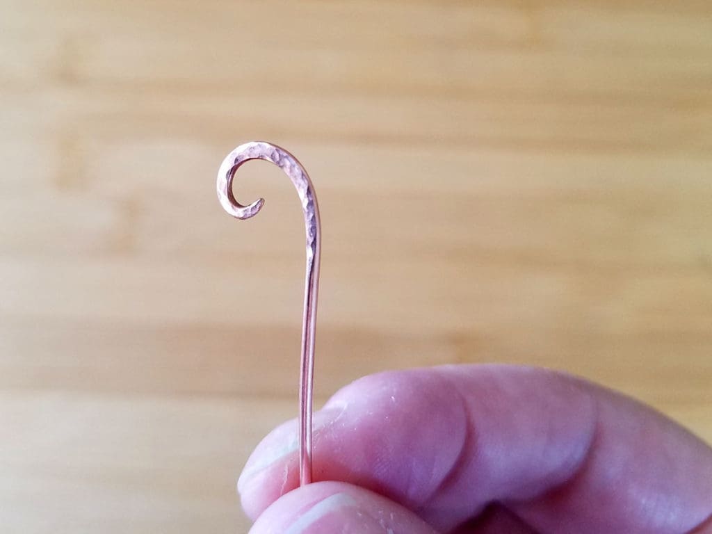 A closeup image of the wire curl formed in our last lesson and textured in this lesson.