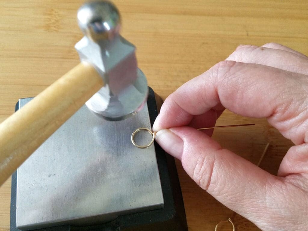 Using a chasing hammer and bench block to work harden the wire loop