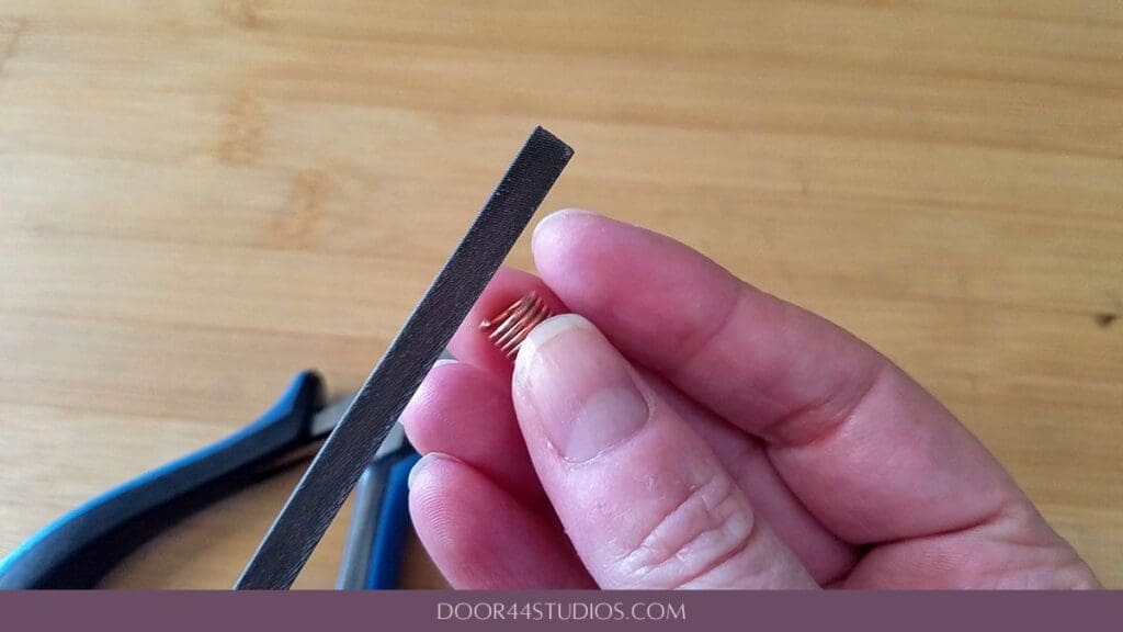Filing the first cut of a rough-cut jump ring